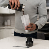 Coffee grounds being poured into filter bag